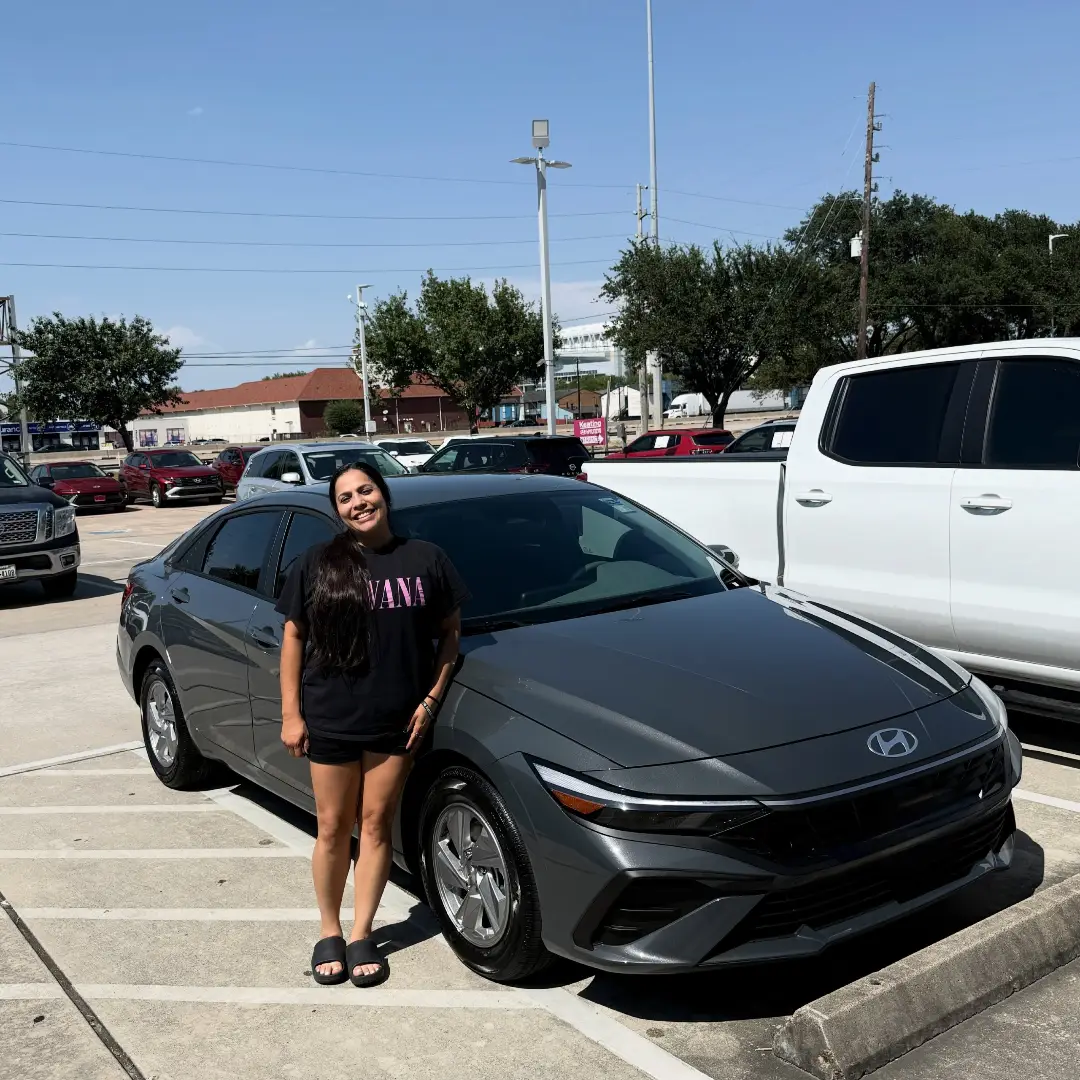 Customer standing beside a black sedan