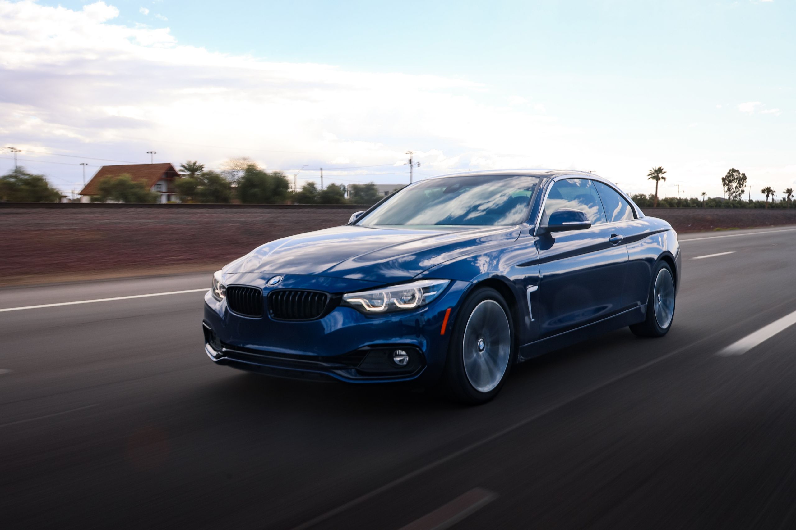 Blue BMW M4 on an open road, illustrative stock photograph